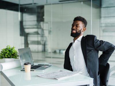 Homem sentindo desconforto físico no ambiente de trabalho