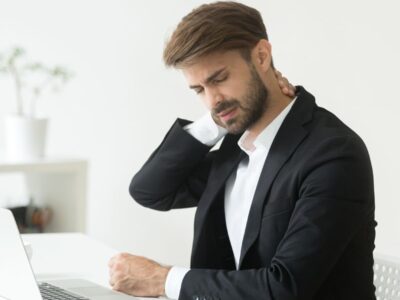 Homem sentindo desconforto físico no ambiente de trabalho