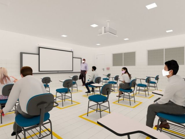Sala de aula com alguns alunos sentado e professor em frente ao quadro branco