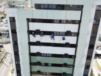 Colaboradores da SLEF Engenharia em acesso por cordas realizando a lavagem da fachada
