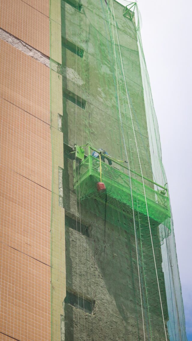 Colaborador da SELF Engenharia retirando acabamento antigo da fachada do Condomínio Lustosa da Câmara